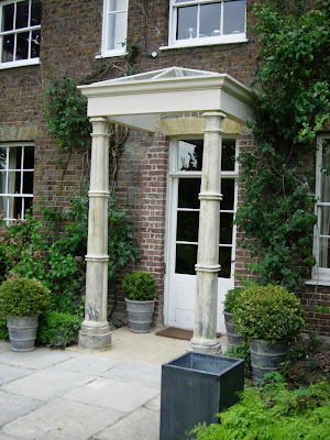 New Bathstone string course above antique pillars erected on a bathstone base 