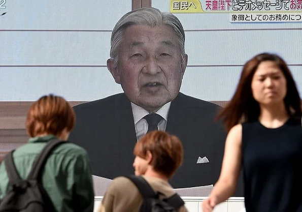 Pedestrians watch a large screen broadcasting Japanese Emperor Akihito's video message on his thoughts in Tokyo. Crown Prince Naruhito and Crown Princess Masako