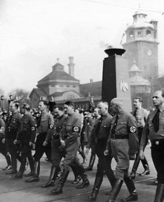 Hitler leading the procession over the Ludwigsbrücke with Müllersche Volksbad behind.