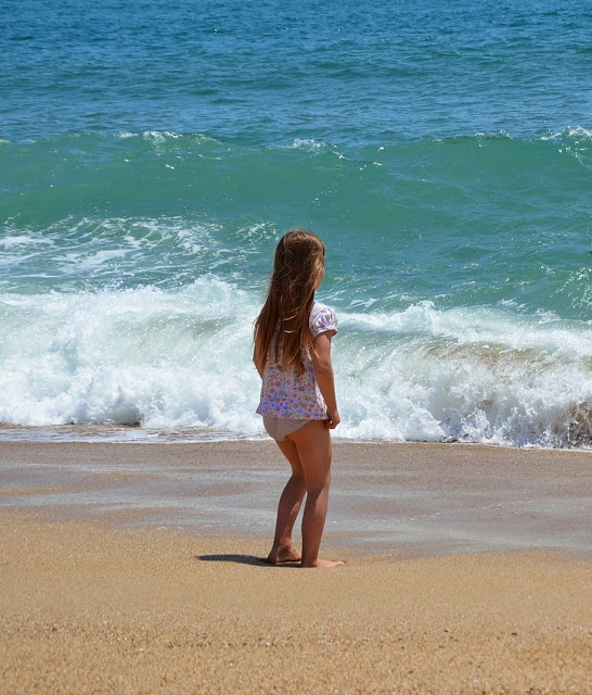 Kind steht am Strand