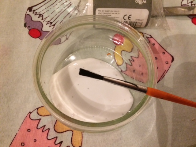 Small jar containing PVA glue and a paint brush