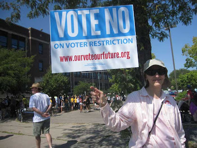 Woman holding official Vote No on Election Restrictions sign