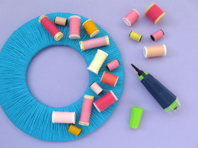 DIY Upcycled Sewing Thread Reels Wreath Tutorial decorating the wreath with the upcycled thread reels