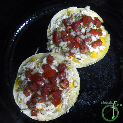 Morsels of Life - Chicken Tostadas Step 2 - Layer cheese, tomatoes, and chicken on a tostada. Heat until cheese melted. Place another tostada on top and garnish with additional tomatoes and avocado.