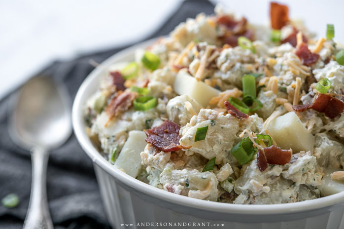 Dish of bacon ranch potato salad with spoon