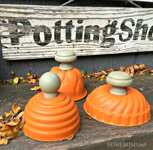 Orange painted tins with fall leaves in front of a potting bench sign