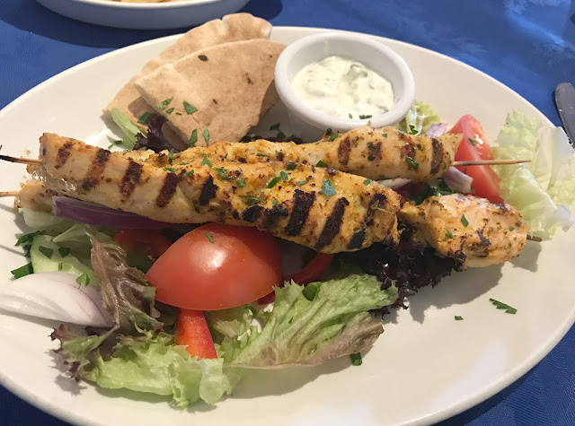 Greek meal chicken kebab salad dip and pita bread 