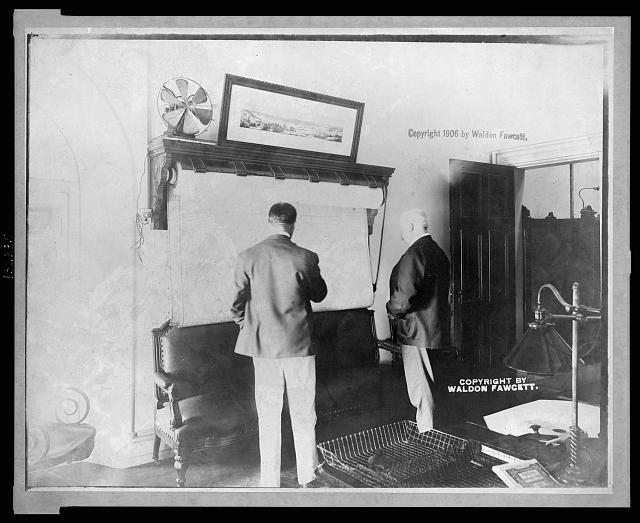 1906: U.S. Secret Service Chief John E. Wilkie examining map in his office