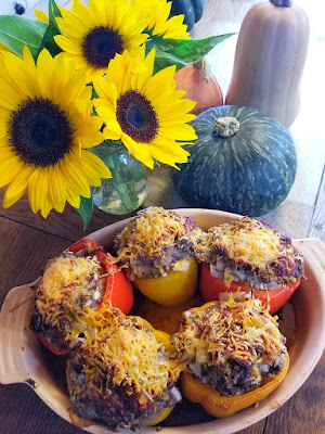 Low carb baked stuffed peppers with a filling of beef, vegetables and cheese in a baking dish