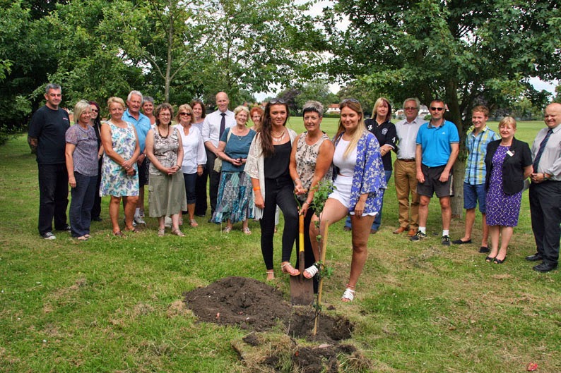 Jane Gibbons, centre, plants a tree in memory of Adrian Gibbons, long-serving teacher at Sir John Nelthorpe School, Brigg, flanked by daughters Kelly (left) and Lucy.