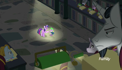 Twilight stands in a spotlight, accompanied by Spike and with the EEA staff looking down on her