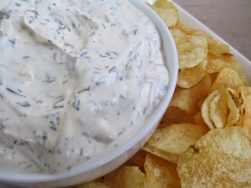 Close-up overhead shot of dill dip in a bowl surrounded by Lay's Kettle Cooked potato chips