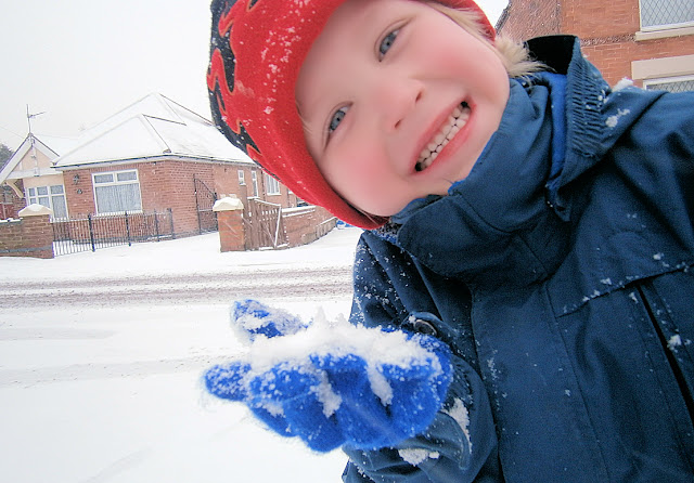 boy making snowballs 
