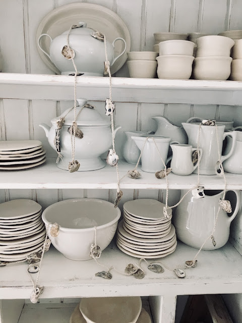 French oyster shell garland and hand thrown pottery dishes by Burlap Luxe on Hello Lovely