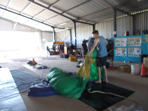 Skydiving crew preparing the parachutes for the "Tandem Skydiving" teams.