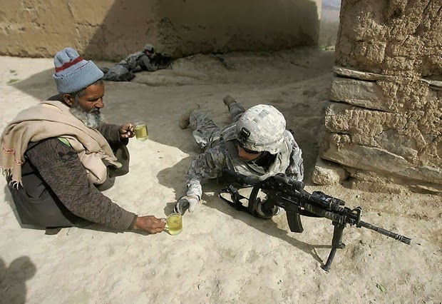 An Afghan man offers tea to soldiers