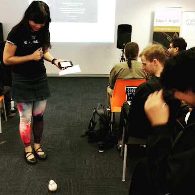 Woman at a conference looking at a BB-8 robot toy.