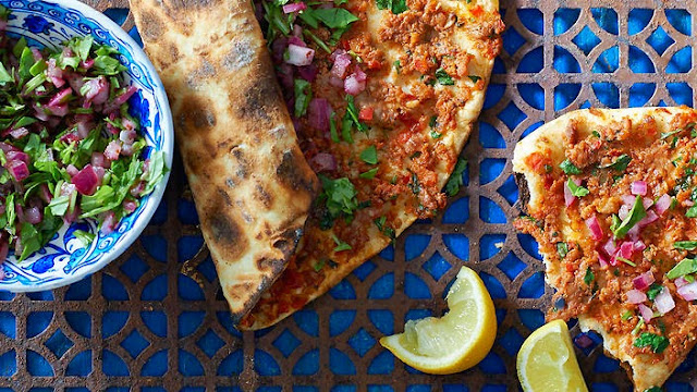 Thin-crust pide with spicy lamb topping and salad bowl