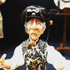 One-twelfth scale miniature doll with steam-punk hat and goggles.