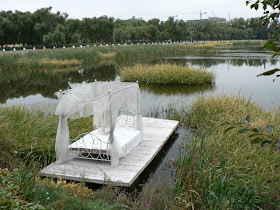 wedding bed set on a platform in a lake