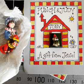 One-twelfth scale miniature Punch and Judy figures next to a card which reads 'Punch and Judy Toby A gift from Jewel' 