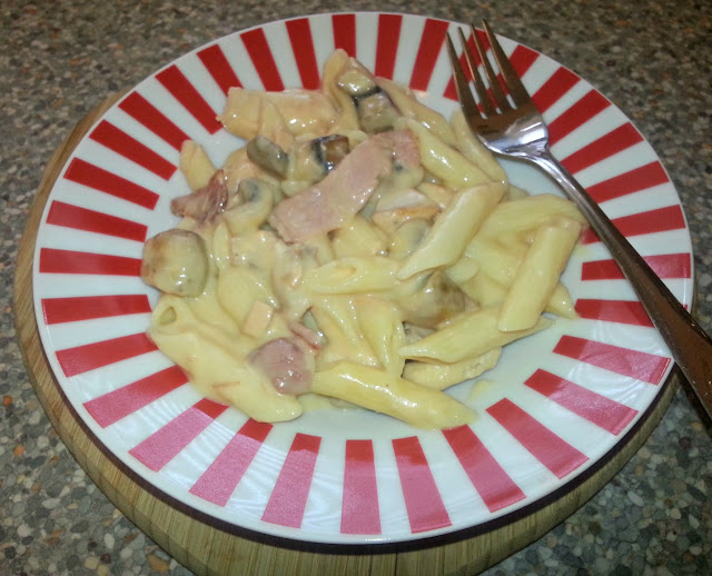 Chicken and bacon pasta in striped dish