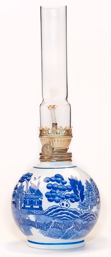 Fairly modern, this small oil lamp with straight glass chimney has the blue willow pattern on it's china base.