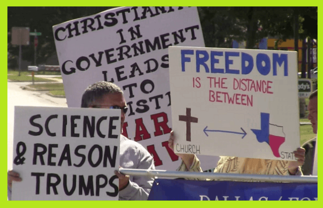 Protesters holding signs that support science and the separation of church and state. They're opposed to Reclaiming Texas For Christ.