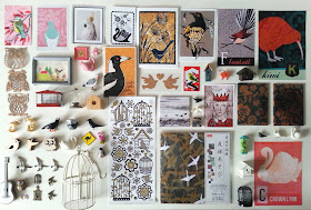 Flat lay of various bird-themed pictures and dolls house miniature accessories