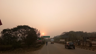 Sunset with the Mile hording showing how far is Guwahati from Sonapur 