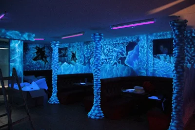 Malowanie ścian w klubie farbami fluorescencyjnymi, malowidło świecące w ciemności, black light