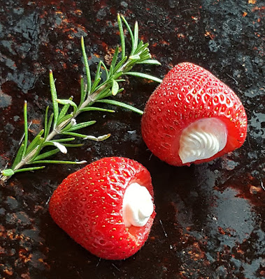 Ripe seasonal strawberries stuffed with a mixture of goat cheese and cream cheese with lemon zest and fresh rosemary