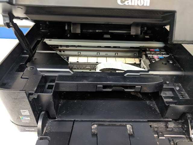 Impresora Canon con la puerta que da acceso a los depósitos de tintas abierta.