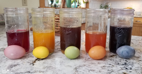Mason jars of dye behind Easter Eggs