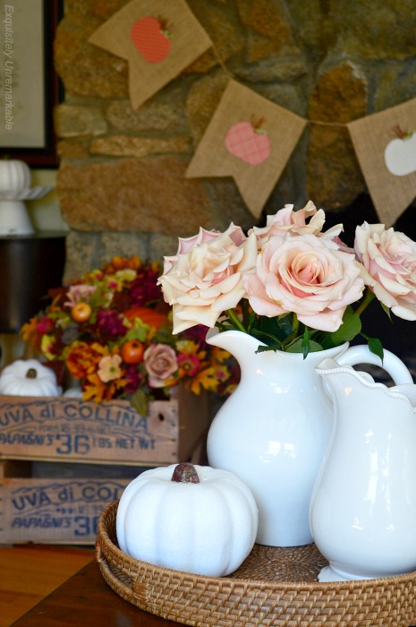 Cottage Style Fall living room with roses and pumpkins on a table and stained crates in the background filled with flowers and pumpkins