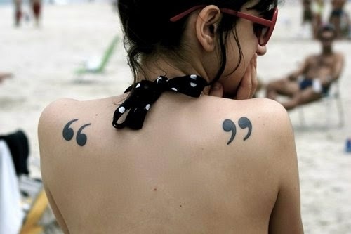 Garota de óculos com aspas tatuadas nas costas, fazendo pose na praia, direto de frases de Sun Tzu e d'A Arte da Guerra.