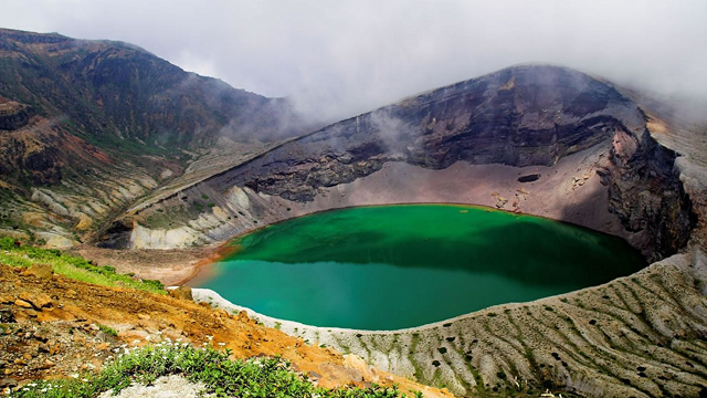 Lago circular cercado de rochas - cor verde claro