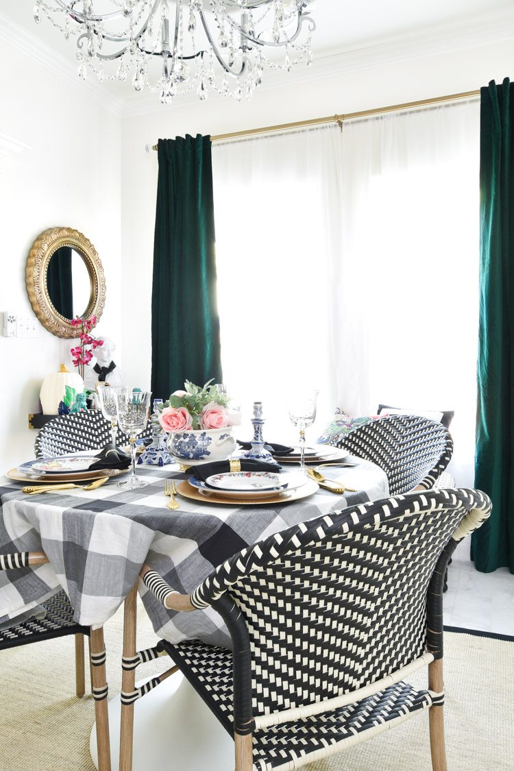 Kelly green or emerald green curtains Green velvet curtains add color to a black, white and gold decorated dining room with alabaster white walls and bistro dining chairs.