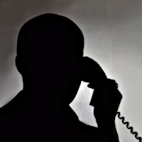 Ankesörlü bir telefondan muhbirlik yapan gizli bir adam silueti