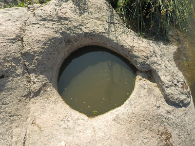круглое отверстие правильной формы в гранитной скале заполнено водой, Южный Буг