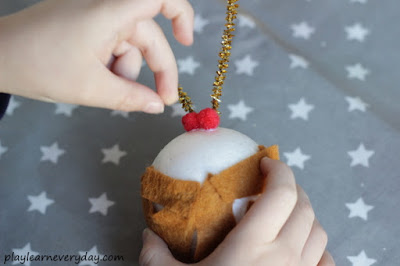sticking berries onto christmas pudding craft