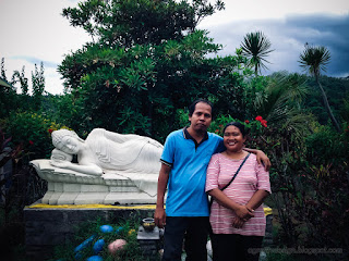 Happy Couple Man And Woman In The Sweet Garden With Sleeping Buddha Shrine At Buddhist Monastery North Bali Indonesia
