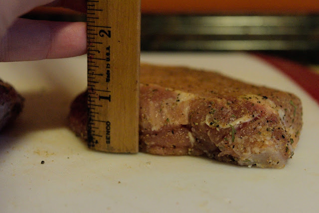  Measuring the thickness of the pork chops with a ruler.