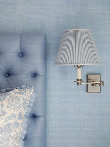 Detail of the headboard and accent pillow as well as small wall mounted reading lamp
