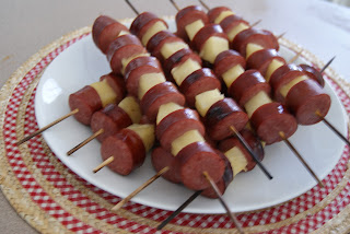 Sausage and potato kebobs served on a white plate.