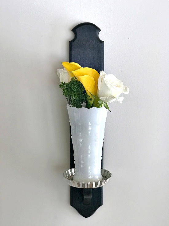 Fresh flowers in a white vase on candlestick base