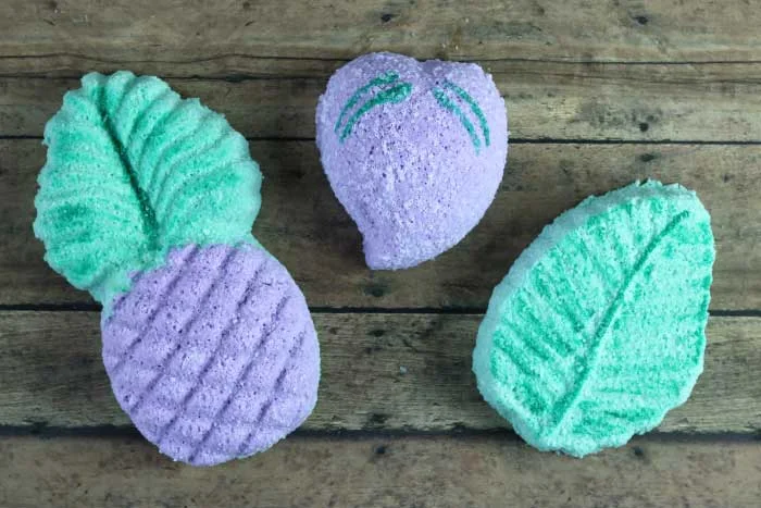 How to make bath bombs without cornstarch.  This simple natural bath bomb recipes is easy to make.  Make DIY homemade bath bombs with the best molds for best results.  Get ideas for easy bath bombs made with cute pineapple, flower, and plum molds.  These fizzy bath bombs are fun to make and fun to use.  If you need bath stuff diy and diy bath stuff recipes, check this out.  How to make bath bombs with Epsom salts.