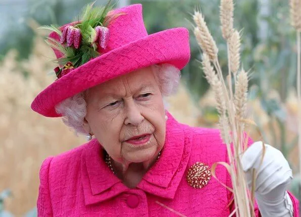 Queen Elizabeth wore a floral satin dress, pink coat and pink hat, pearl necklace, pearl earrings and diamond brooch