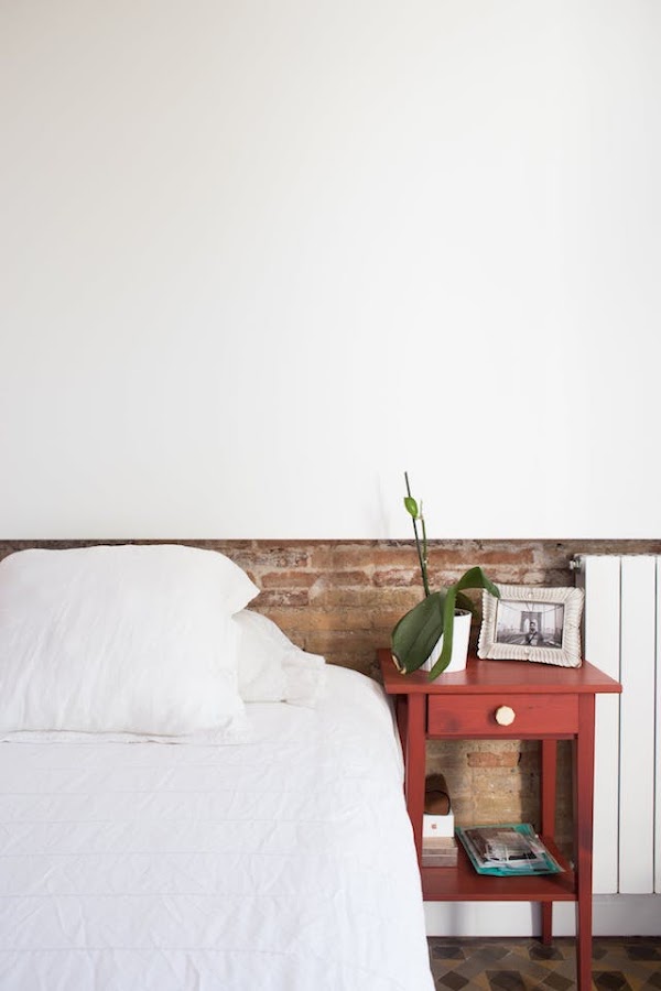 dormitorio con media pared de mampostería y suelos hidráulicos. 