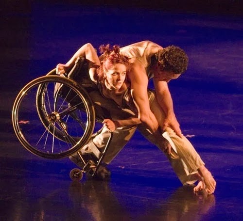Woman in a wheelchair dancing with man